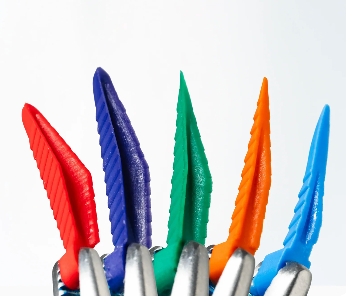 FlexiWedge interproximal wedges in red, purple, green, orange and blue held in pliers